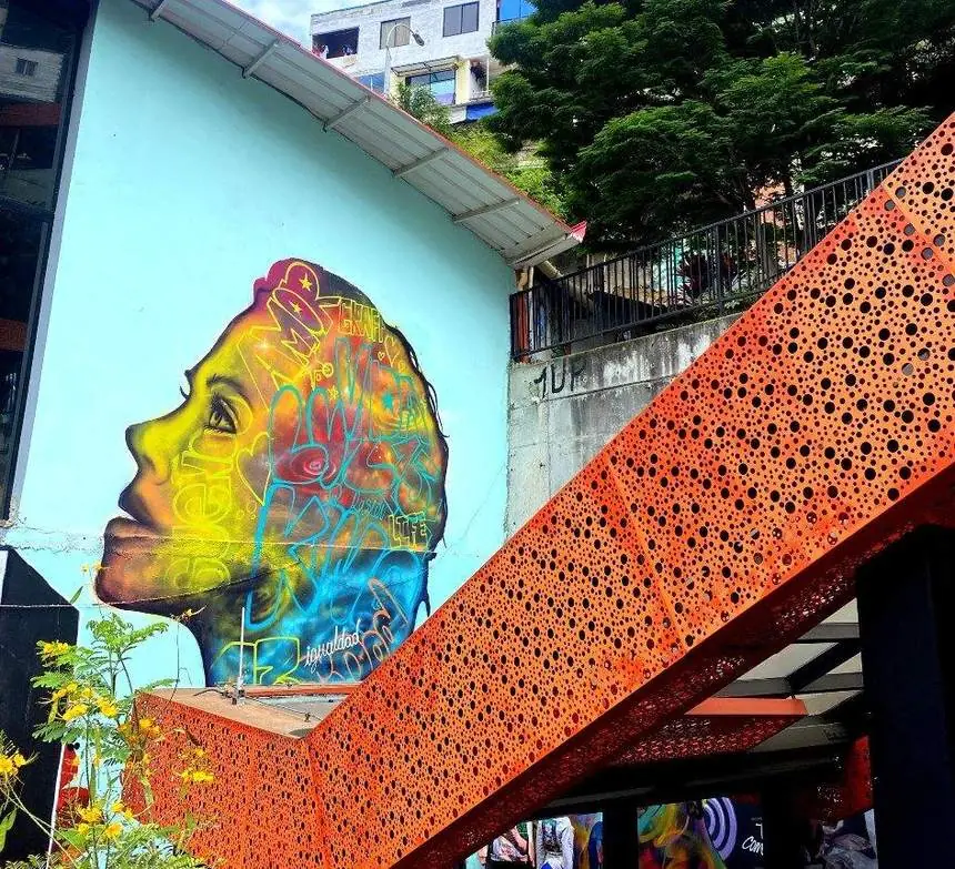 Mural de un rostro junto a las escaleras eléctricas de la Comuna 13