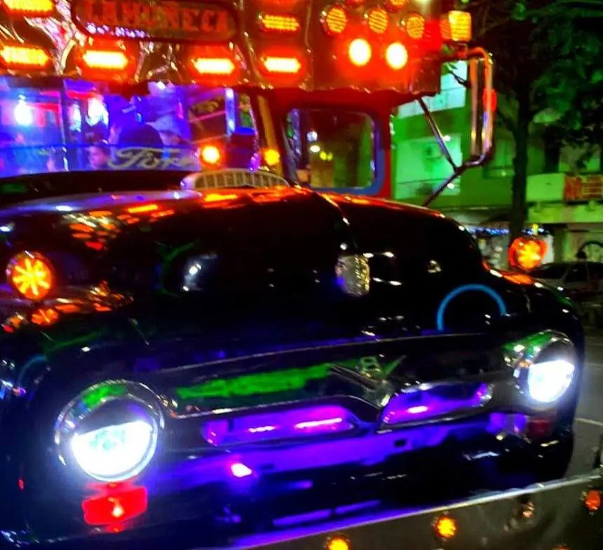 Frente de una chiva rumbera con luces de neón en Medellín