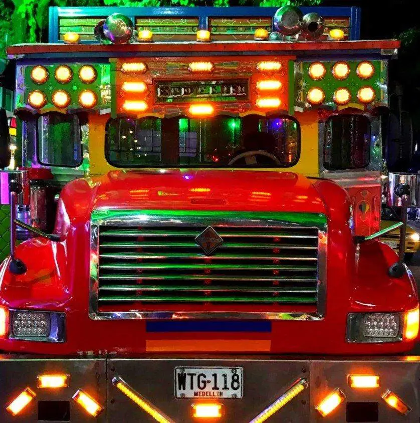 Chiva decorada con luces de colores lista para la rumba nocturna en Medellín
