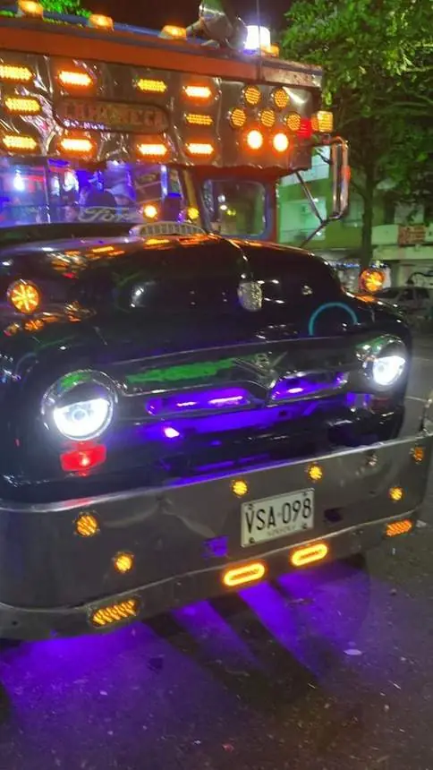 Chiva nocturna con luces moradas y naranjas
