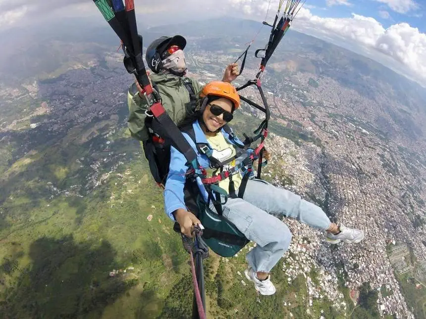 Pasajera y piloto en vuelo de parapente sobre Medellín