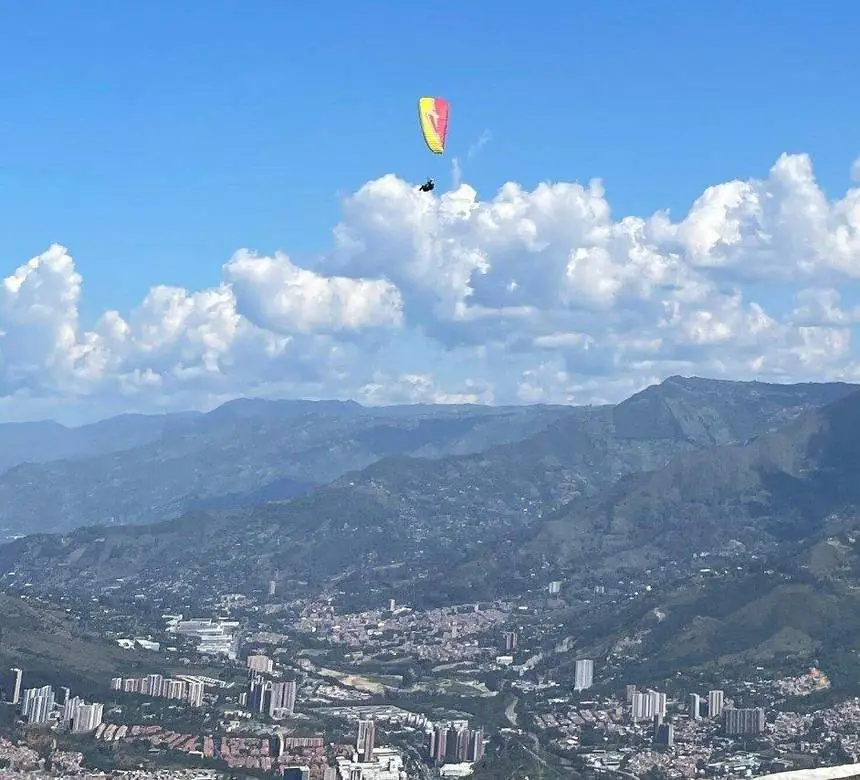 Parapente en el cielo con la ciudad de Medellín abajo
